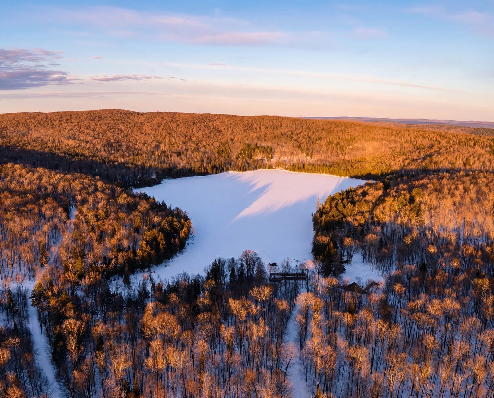 Frozen lake panorama at golden hour, aerial view