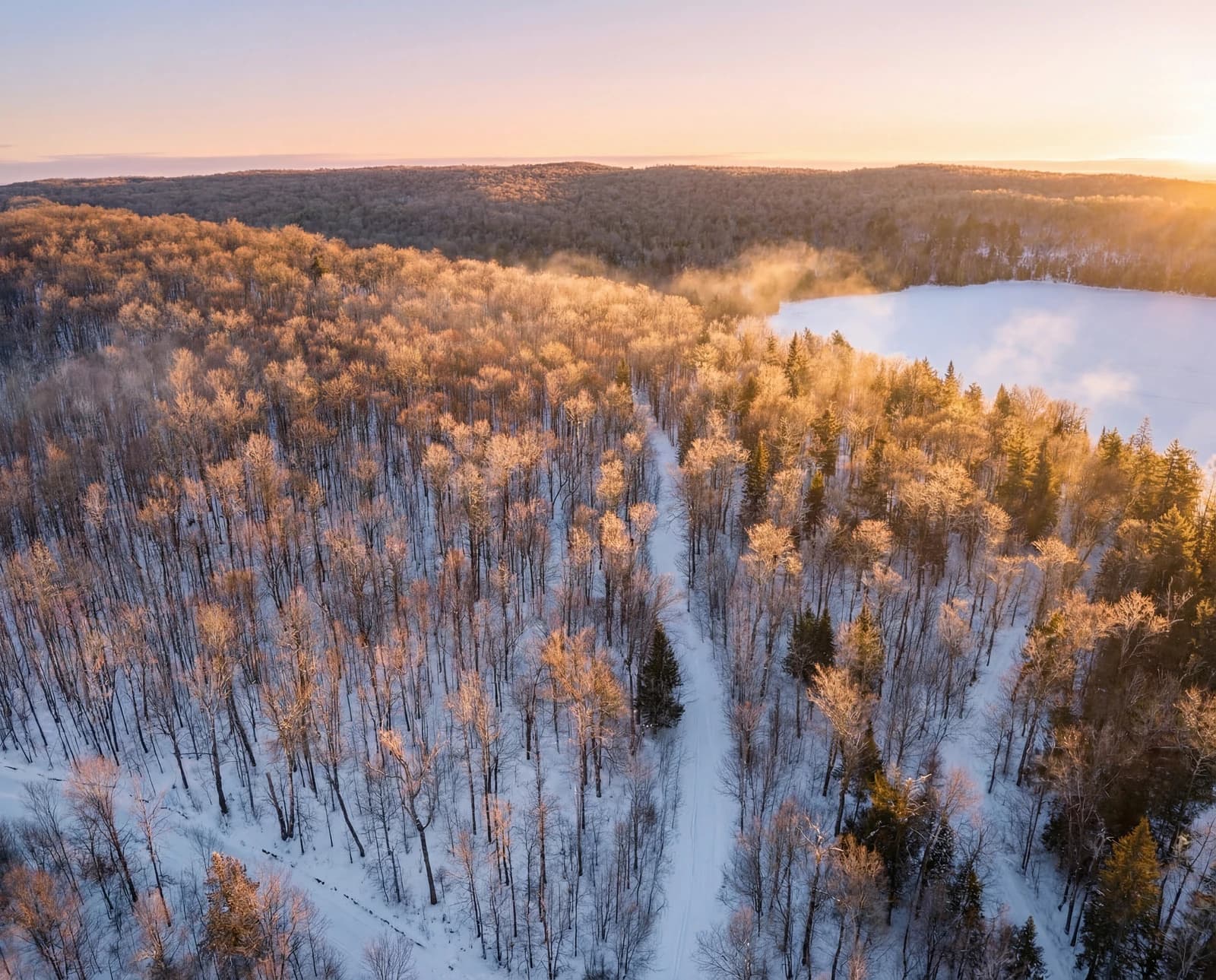 Golden winter sunrise with mist over frozen lake