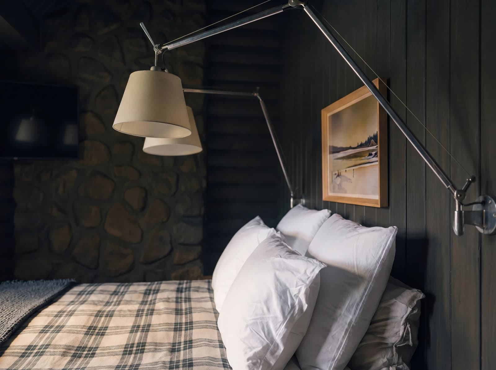 Articulated reading lamp detail with stone wall