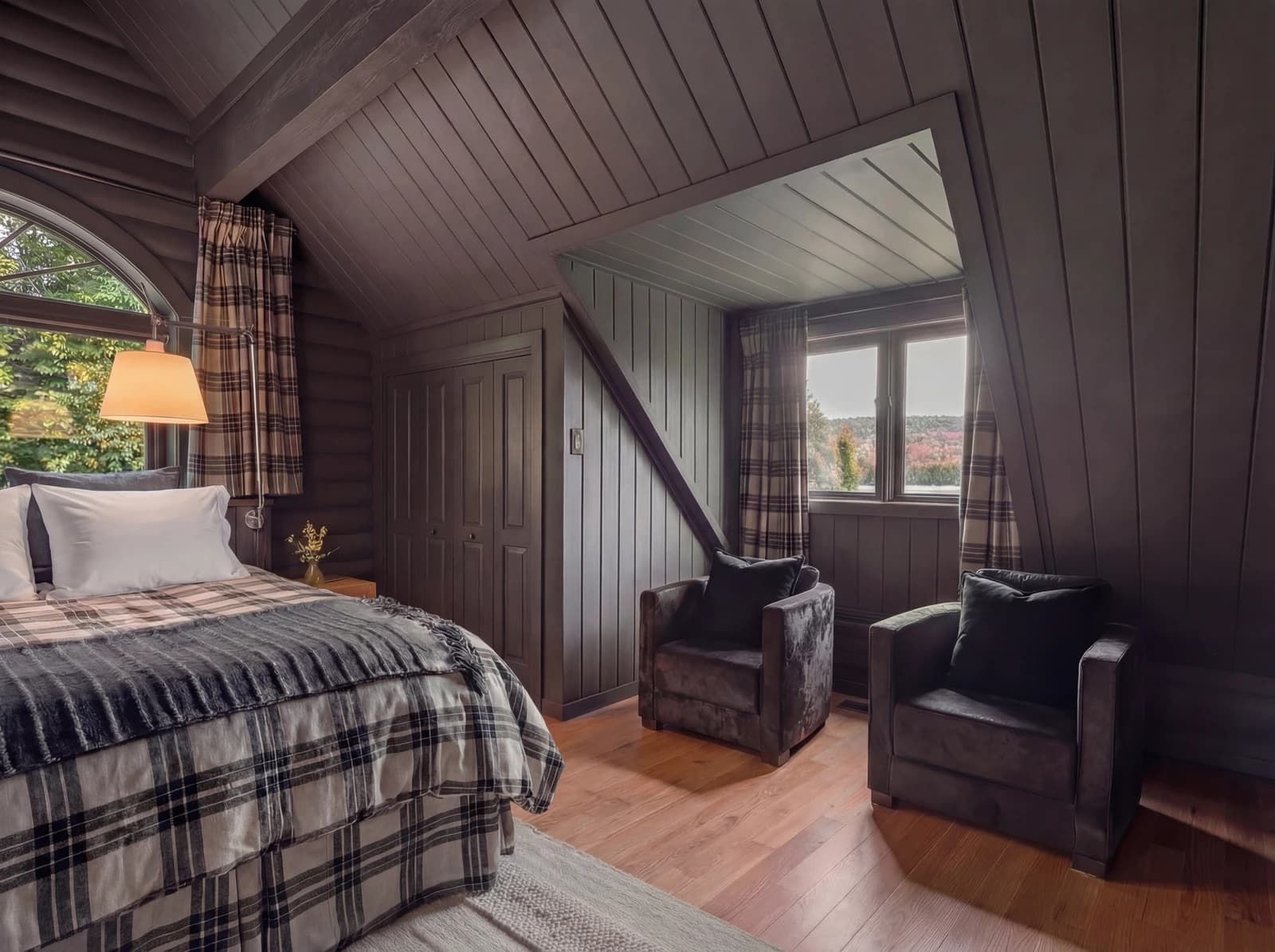 Wide shot of upper bedroom with seating area and autumn view