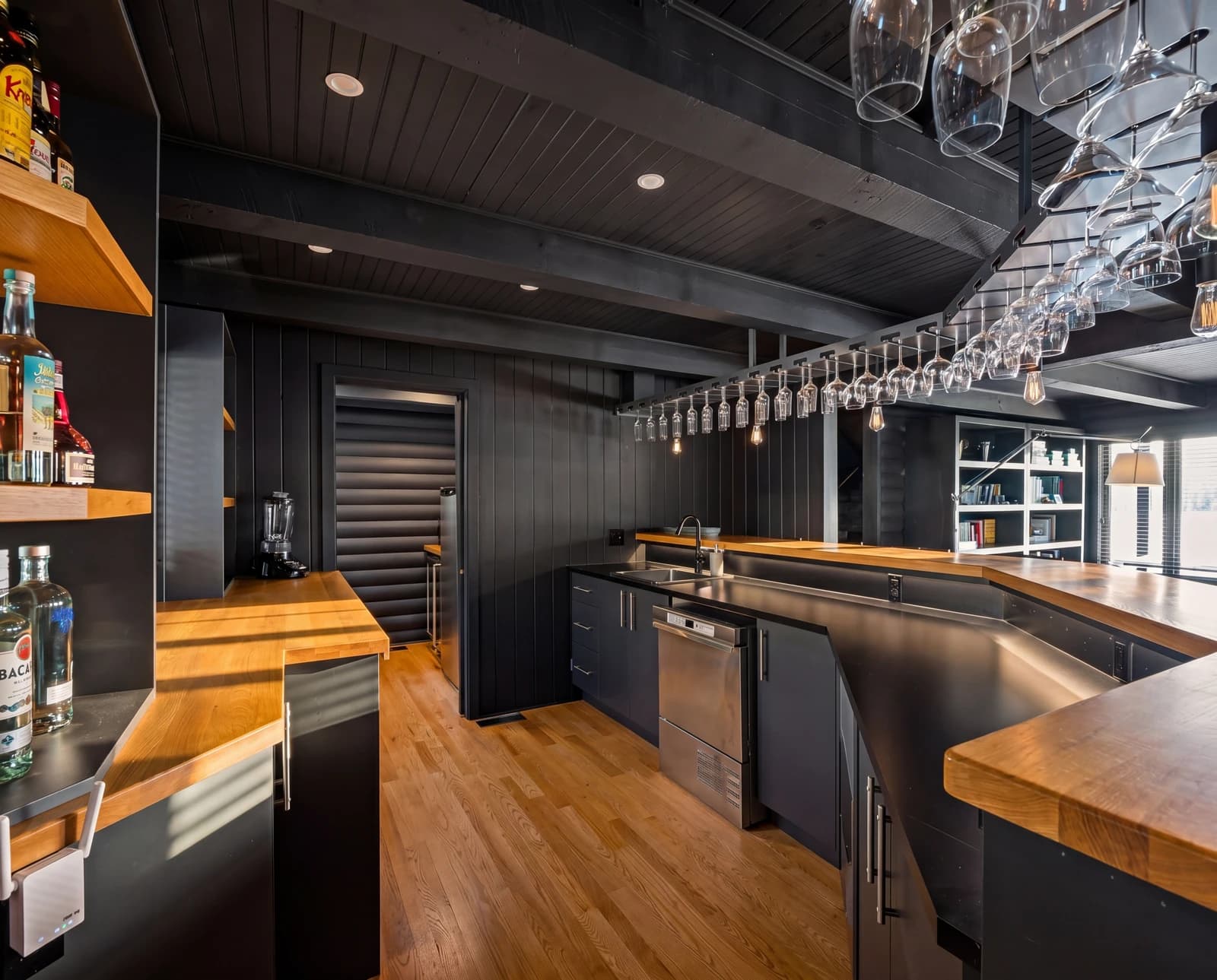 Wet bar with hanging glasses, bottles and butcher-block counters