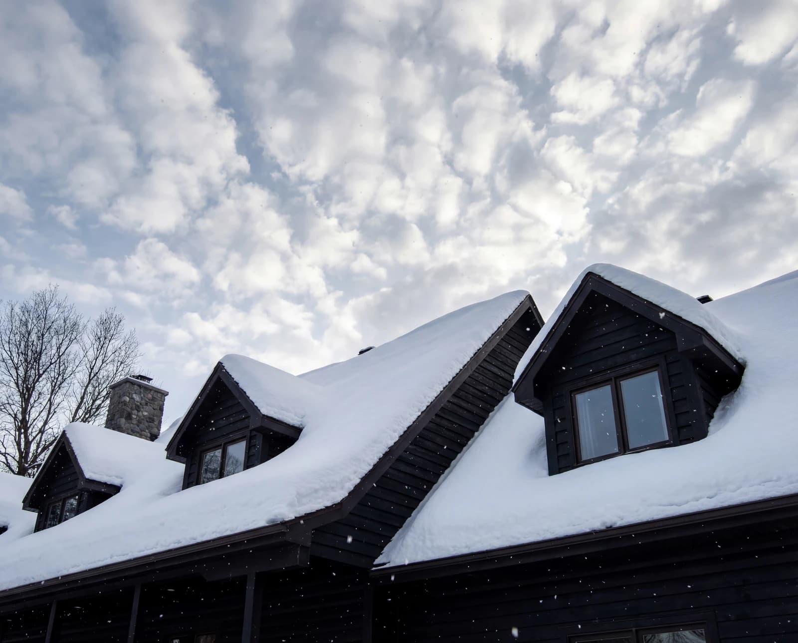 Black cabin rooftops from directly above in snow