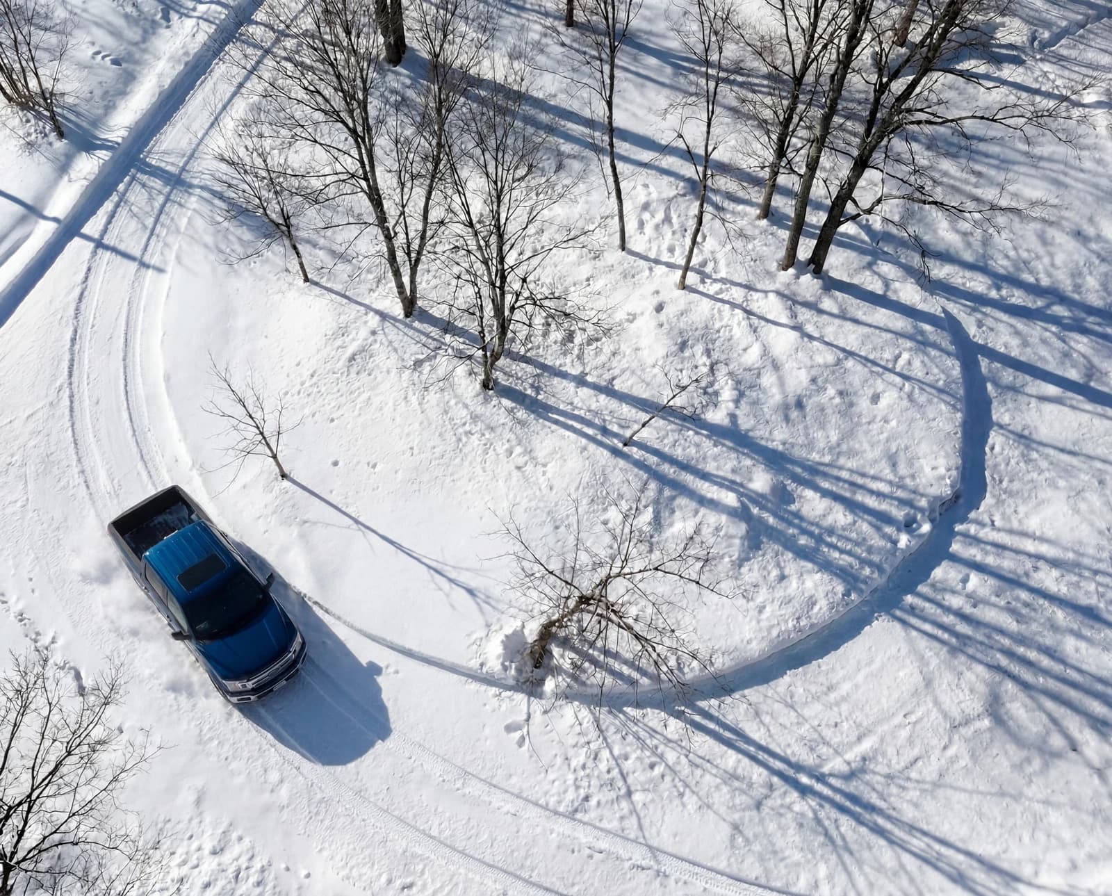 Car on a snowy forest road, from above